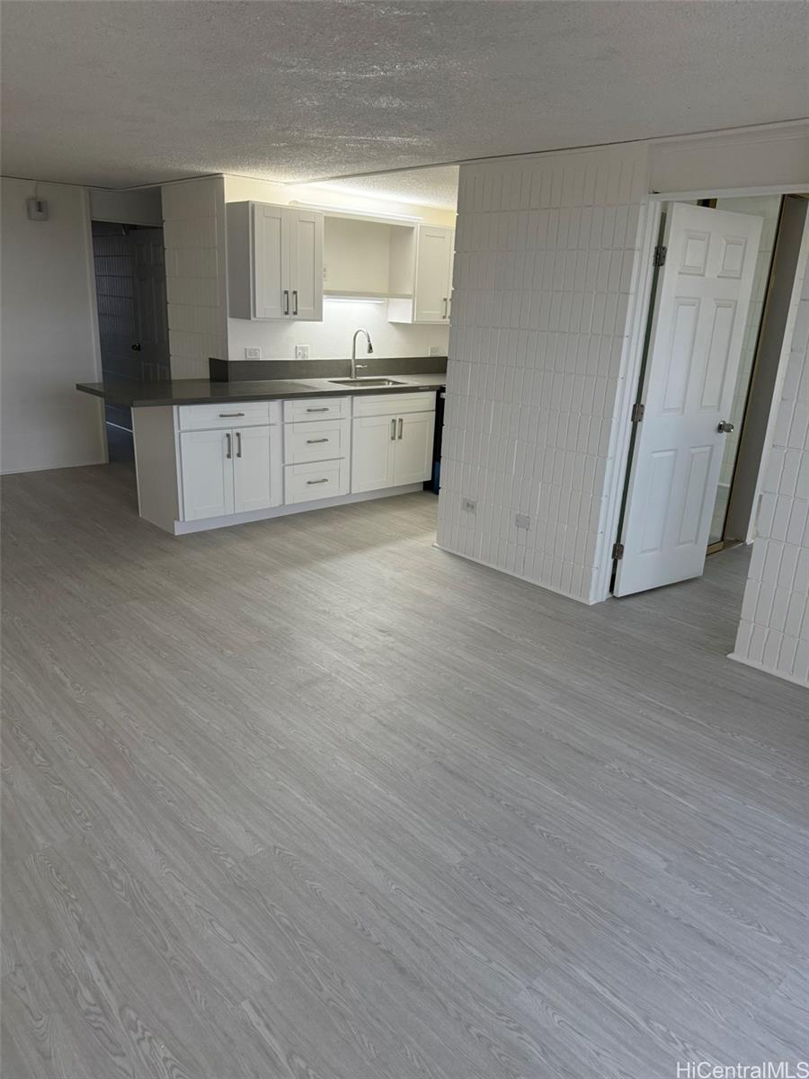 3215 Ala Ilima Street, Unit A1202 Honolulu, HI 96818 - Photo 12 of 20 a room with granite countertop a sink and a refrigerator