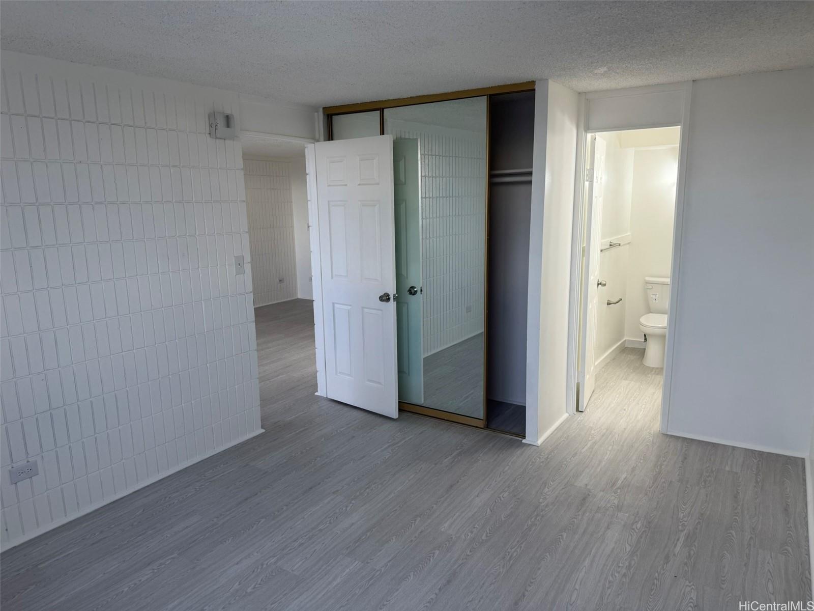 3215 Ala Ilima Street, Unit A1202 Honolulu, HI 96818 - Photo 14 of 20 a view of an empty room with wooden floor and a bathroom