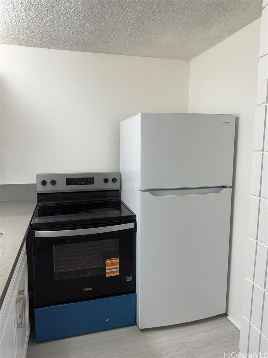 3215 Ala Ilima Street, Unit A1202 Honolulu, HI 96818 - Photo 20 of 20 a kitchen with a stove and a refrigerator