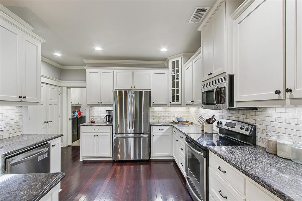 263 West Jefferson Street Van Alstyne, TX 75495 - Photo 14 of 32 a kitchen with granite countertop stainless steel appliances and wooden cabinets