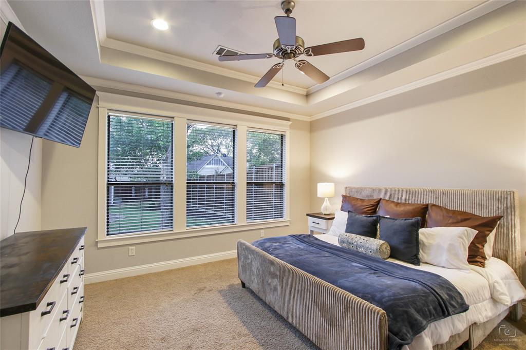 263 West Jefferson Street Van Alstyne, TX 75495 - Photo 20 of 32 a spacious bedroom with a large bed and a chandelier