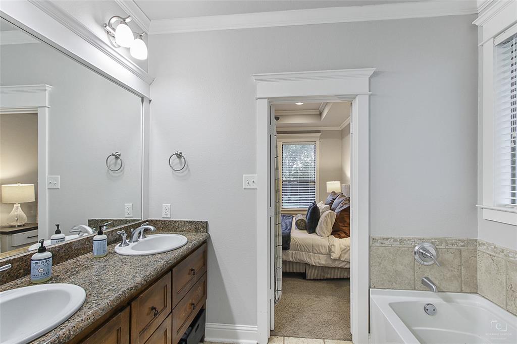 263 West Jefferson Street Van Alstyne, TX 75495 - Photo 22 of 32 a en suite bathroom with a granite countertop tub a double vanity and a sink