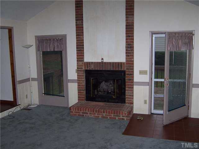 2413 Scouting Trail Raleigh, NC 27615 - Photo 8 of 14 an empty room with fireplace and wooden floor