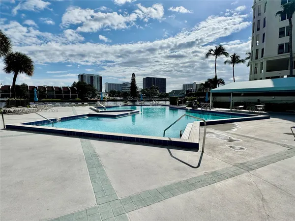 a view of a tennis ground with large trees