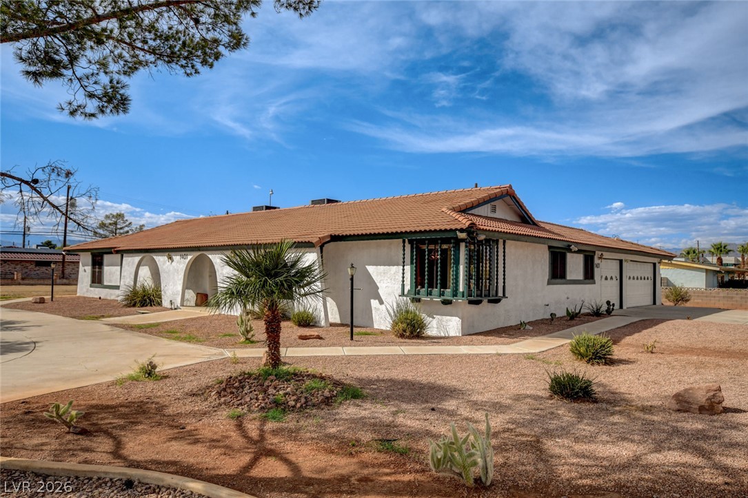 1401 Sharon Road Las Vegas, NV 89106 - Photo 12 of 73 Classic Southwestern architecture sits on a desert landscaped corner lot under a wide blue sky.