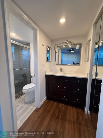 a spacious bathroom with a double vanity sink toilet and a mirror