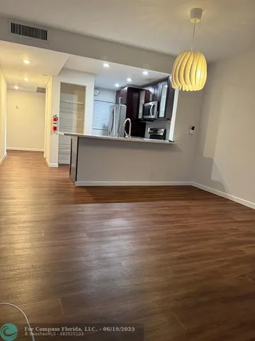 a view of kitchen and hall with wooden floor