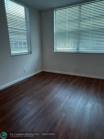 an empty room with wooden floor and a window