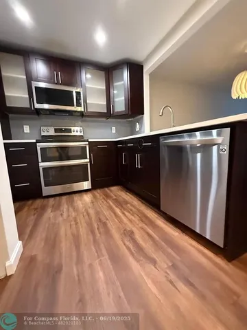 a kitchen with stainless steel appliances kitchen island granite countertop a stove a sink and a microwave