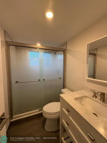 a bathroom with a granite countertop sink toilet and shower