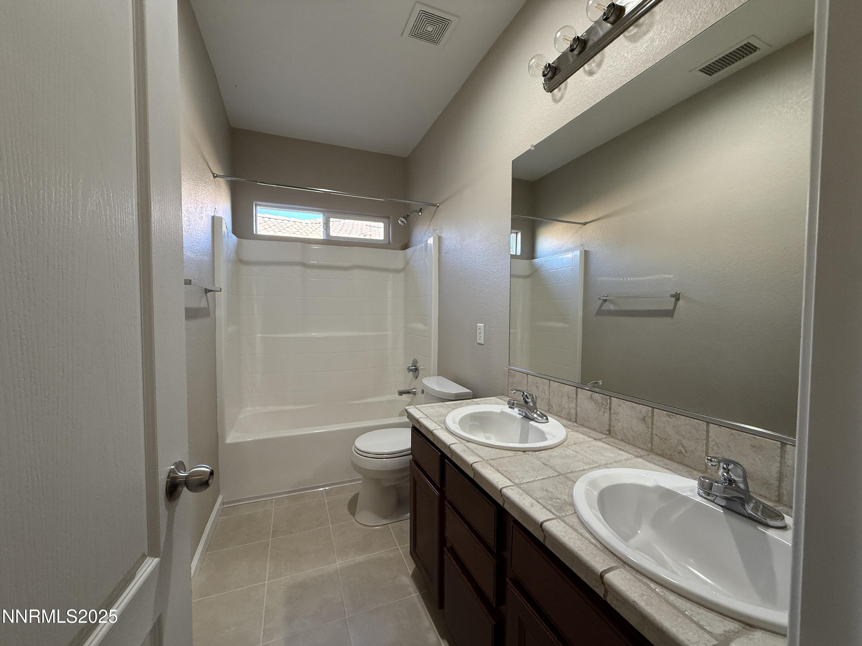 435 Stradella Court Reno, NV 89521 - Photo 17 of 33 a bathroom with a double vanity sink toilet mirror and shower