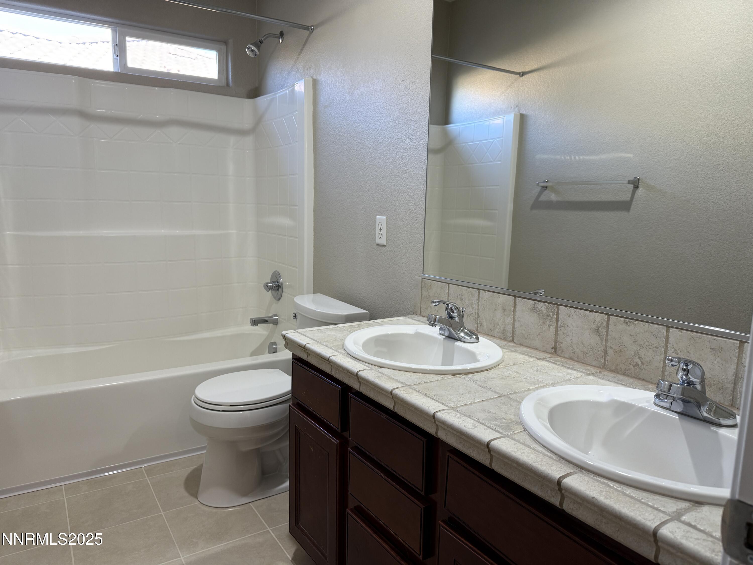 435 Stradella Court Reno, NV 89521 - Photo 32 of 33 a bathroom with a double vanity sink toilet and a bathtub