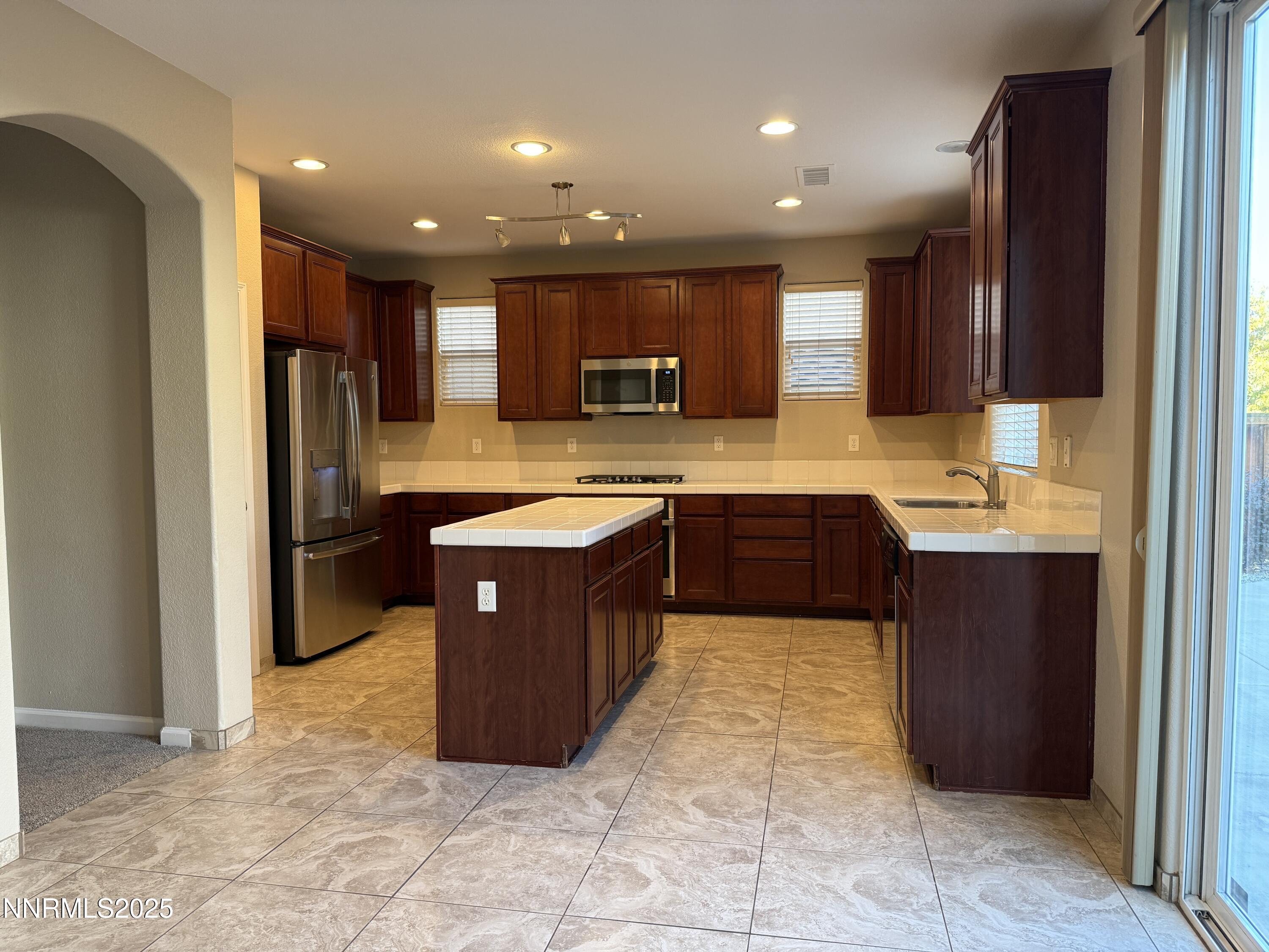435 Stradella Court Reno, NV 89521 - Photo 4 of 33 a large kitchen with stainless steel appliances granite countertop a stove a sink and a refrigerator