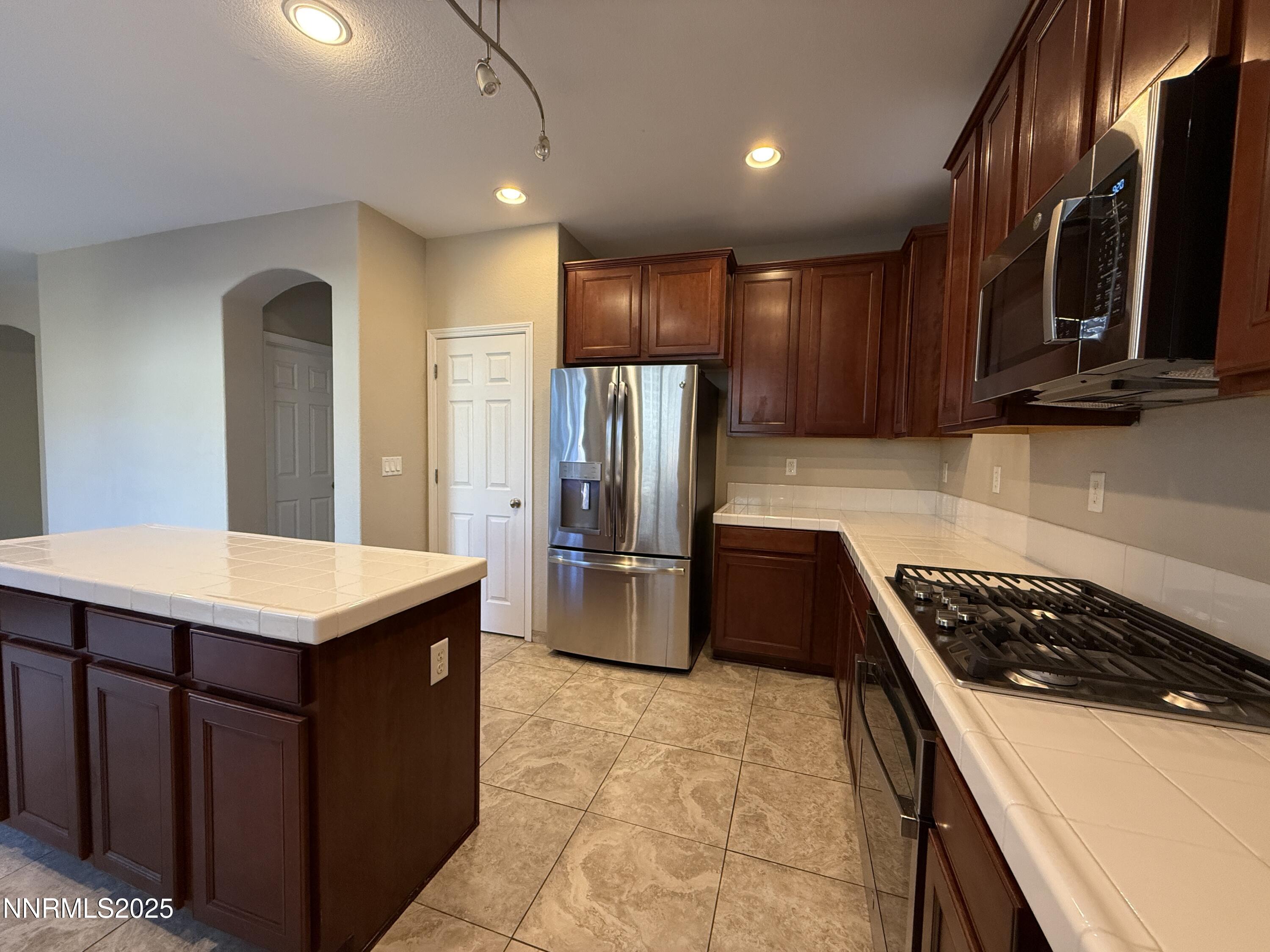 435 Stradella Court Reno, NV 89521 - Photo 8 of 33 a kitchen with stainless steel appliances a stove a refrigerator a sink a stove and island