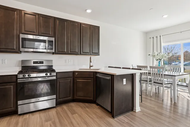 a kitchen with stainless steel appliances granite countertop a stove a sink and a microwave