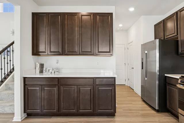 a kitchen with stainless steel appliances granite countertop wooden cabinets a refrigerator and a sink