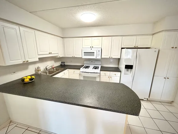 a kitchen with a sink a stove and white cabinets