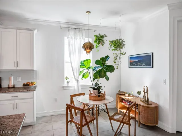 a dining room filled chandelier and kitchen view