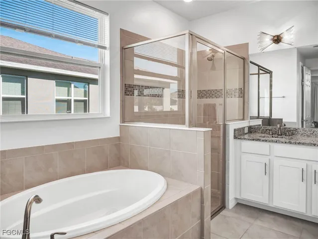 a bathroom with a granite countertop bathtub and a sink