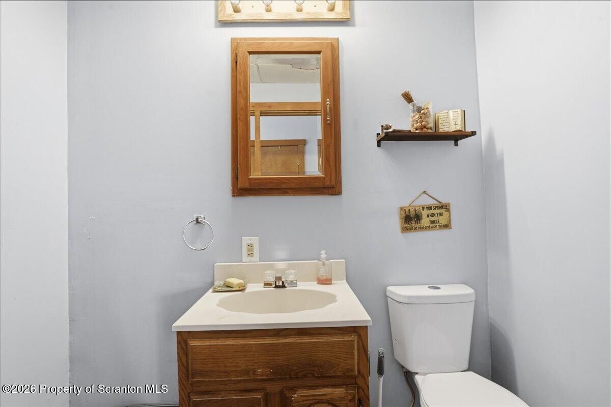 2909 Potter Hill Road Thompson, PA 18465 - Photo 29 of 80 a bathroom with a toilet sink and mirror