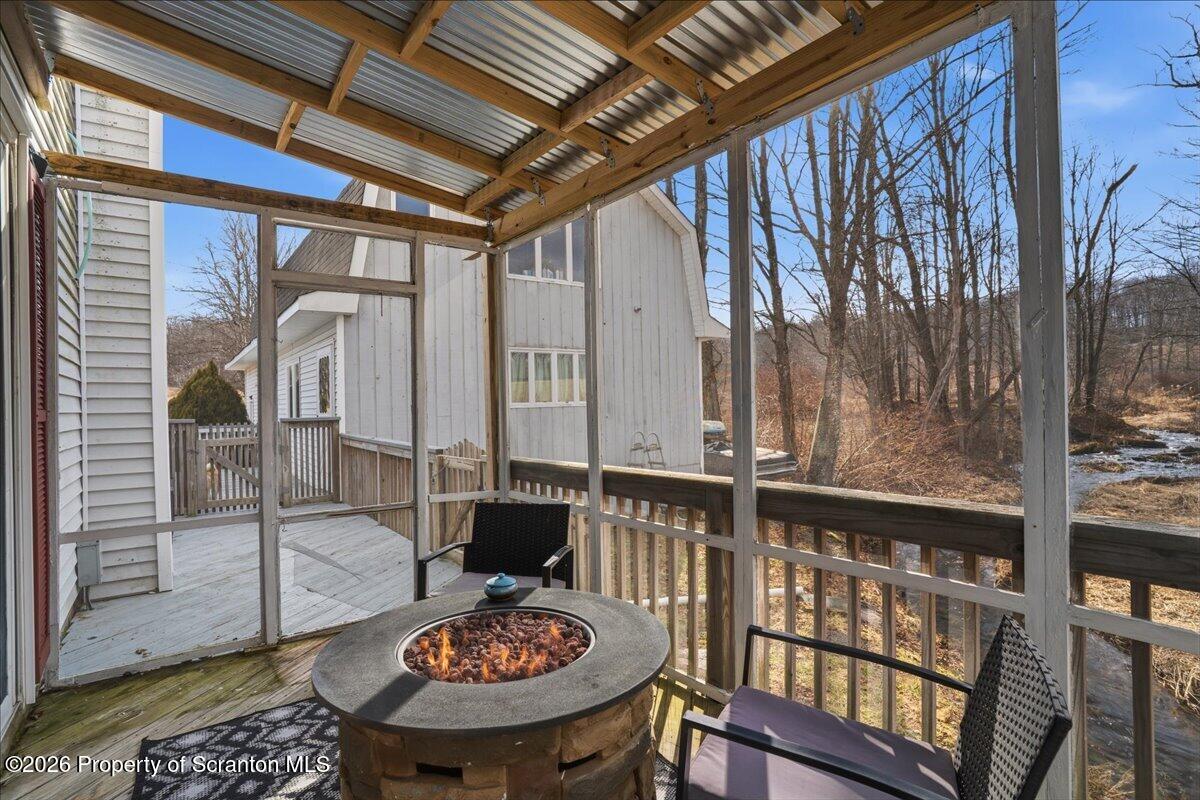 2909 Potter Hill Road Thompson, PA 18465 - Photo 36 of 80 a view of a balcony dining table and chairs