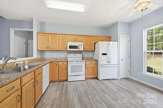 a kitchen with granite countertop white cabinets and white appliances