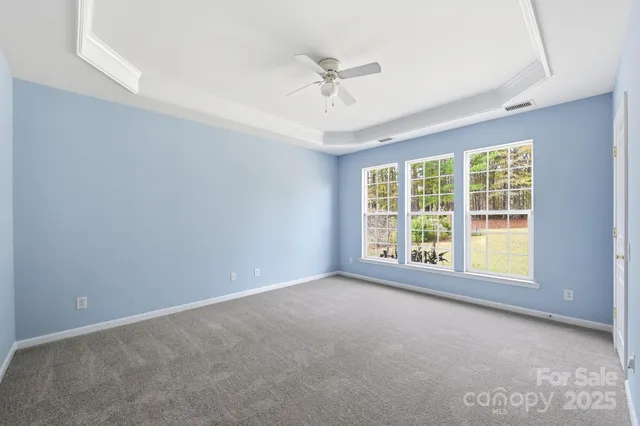 an empty room with a ceiling fan and window