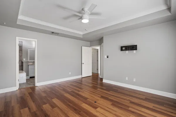a view of an empty room with wooden floor