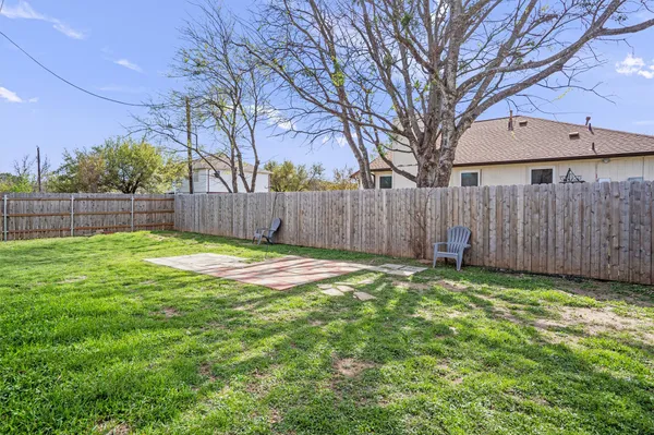 a view of a backyard with a small cabin and wooden fence