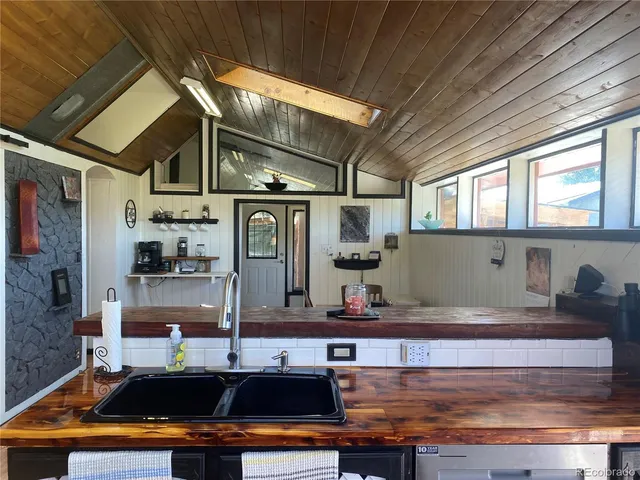 a kitchen with kitchen island granite countertop a sink cabinets and window