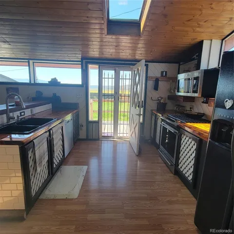 a kitchen with stainless steel appliances granite countertop a stove a sink and a wooden floors