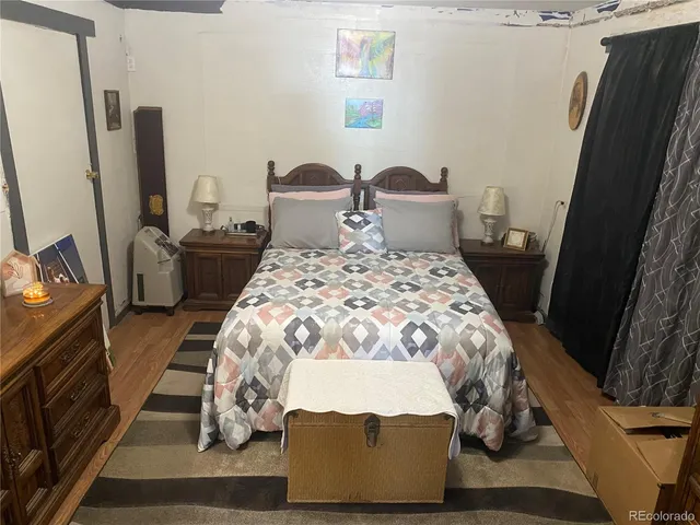 a bedroom with a bed and a flat tv screen on the dresser