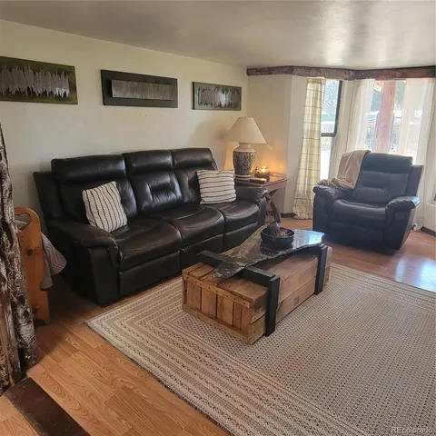 a living room with furniture wooden floor and a large window