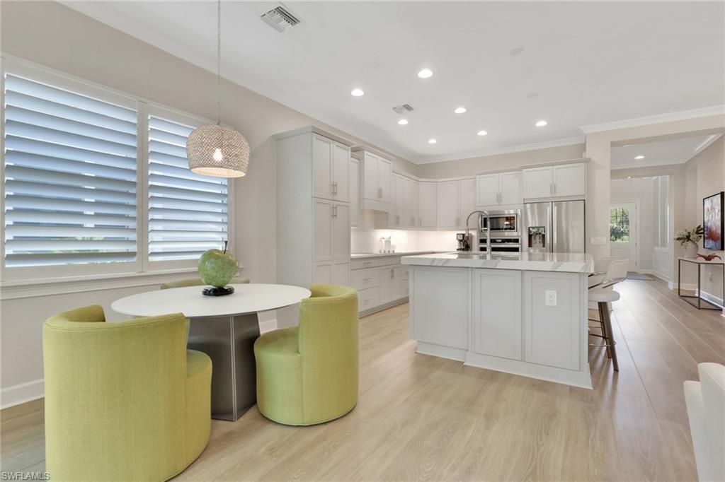 6253 Antigua Way Naples, FL 34113 - Photo 11 of 41 a kitchen with cabinets a sink and appliances