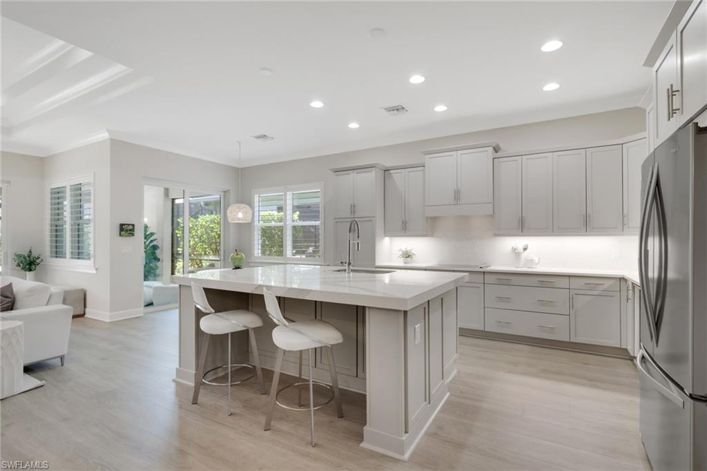6253 Antigua Way Naples, FL 34113 - Photo 13 of 41 a kitchen with kitchen island a sink table and chairs