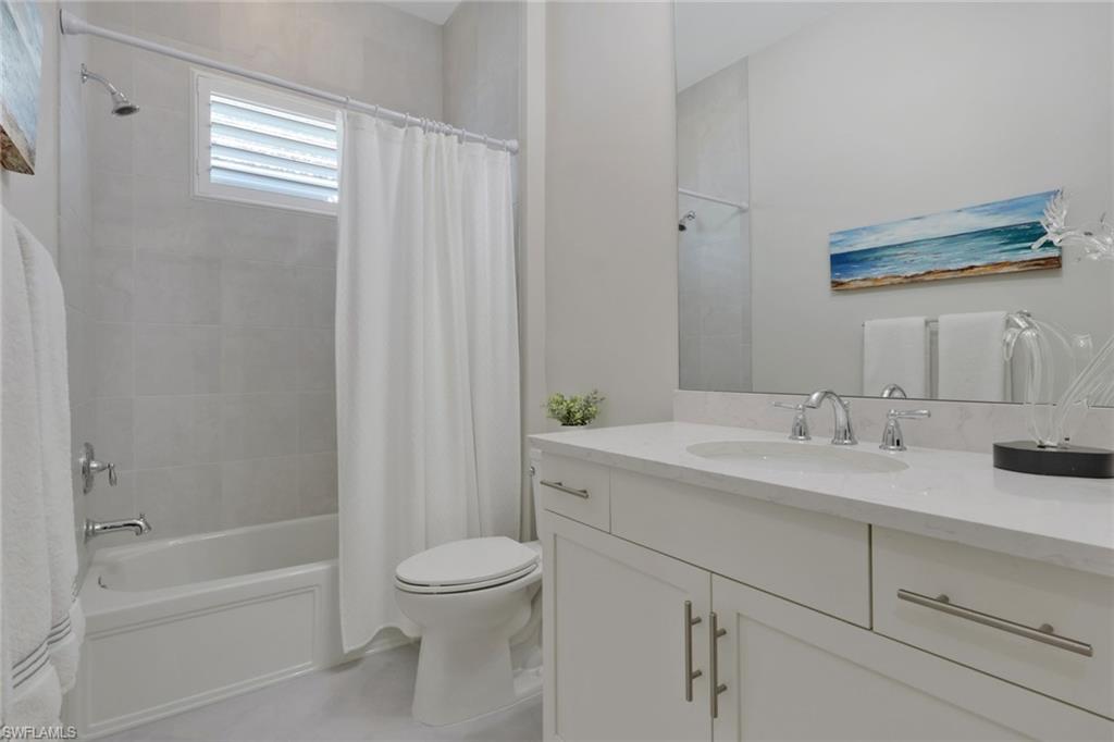 6253 Antigua Way Naples, FL 34113 - Photo 19 of 41 a bathroom with a granite countertop sink toilet and shower