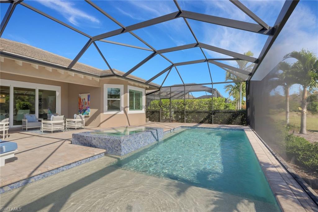 6253 Antigua Way Naples, FL 34113 - Photo 26 of 41 a view of a patio with table and chairs under an umbrella