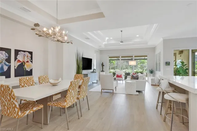 a view of a dining room with furniture a livingroom and chandelier