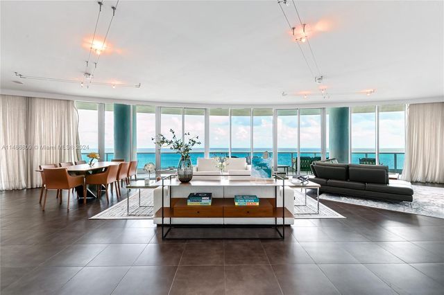 a living room with patio furniture and a large window