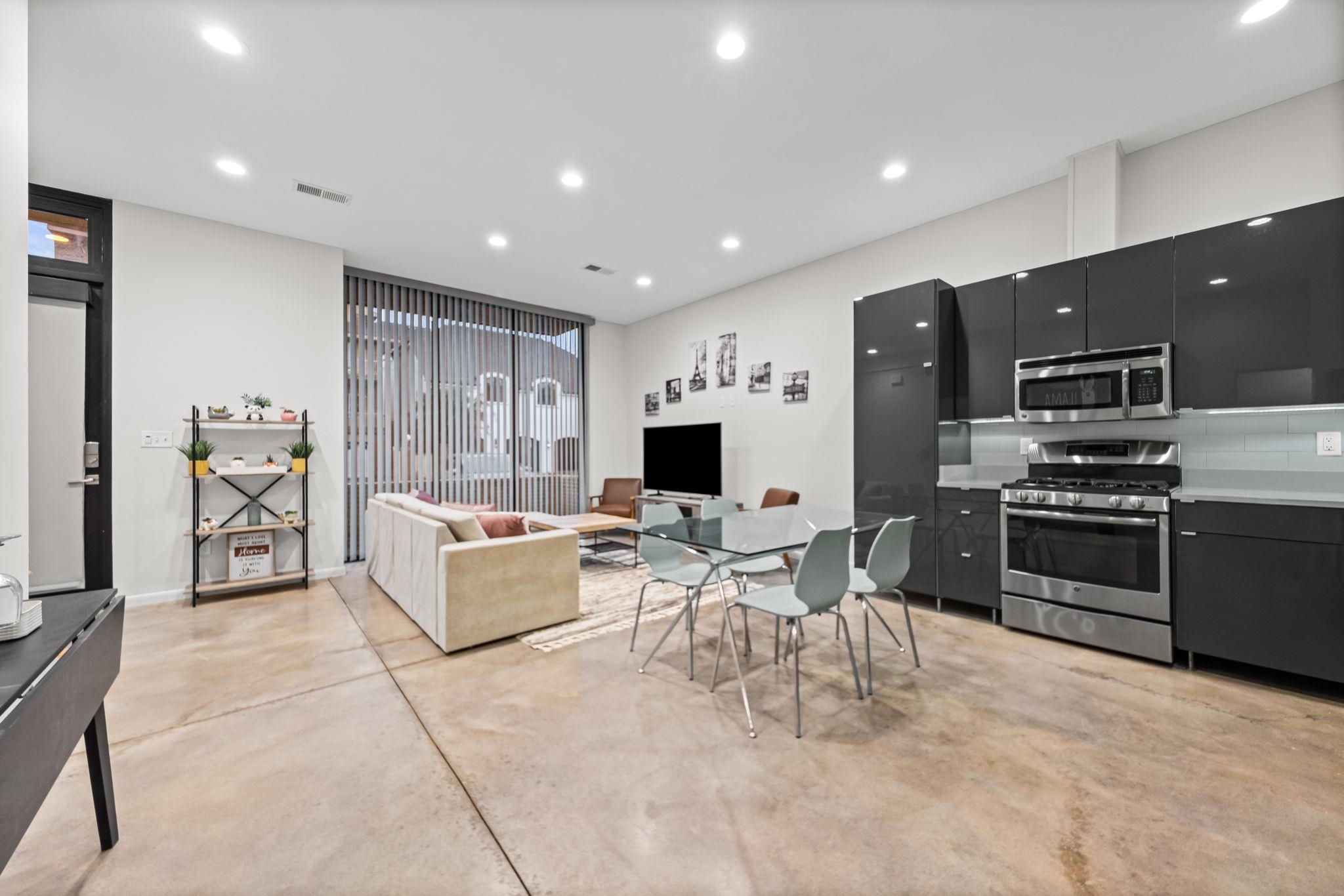 448 Tennessee Street Memphis, TN 38103 - Photo 11 of 39 a living room with stainless steel appliances furniture a flat screen tv and kitchen view