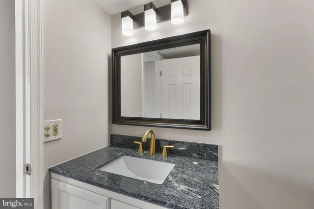 a bathroom with vanity granite and a sink