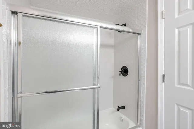a bathroom with a glass shower door