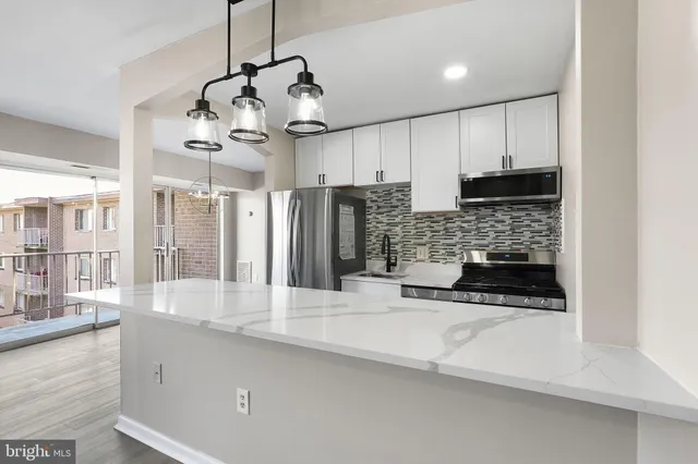 a kitchen with stainless steel appliances granite countertop a sink a stove and a refrigerator