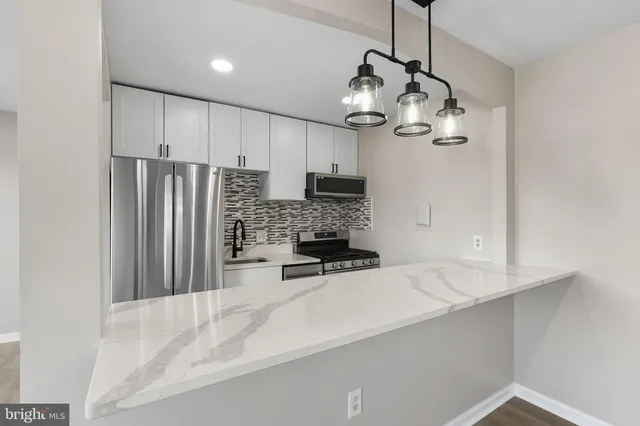 a kitchen with stainless steel appliances a refrigerator sink and microwave