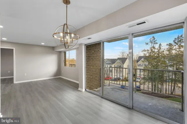 a view of a livingroom with wooden floor and a chandelier