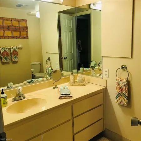 a bathroom with a sink a toilet and mirror