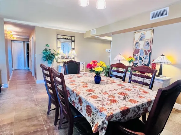 a dining area with a table chairs and a kitchen view
