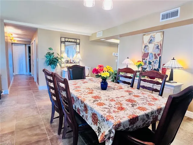 a dining area with a table chairs and a kitchen view