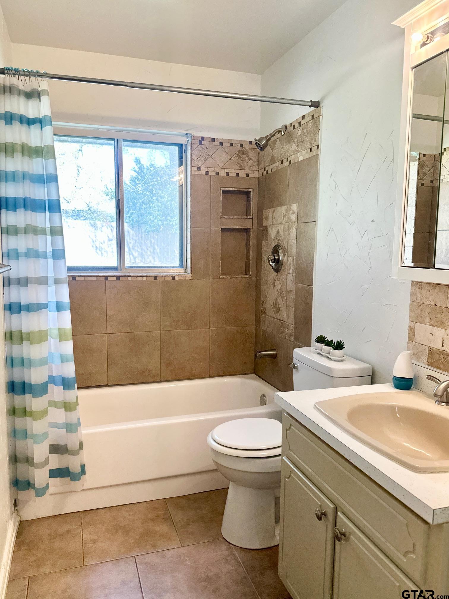 2412 East Devine Street Tyler, TX 75701 - Photo 15 of 27 a bathroom with a granite countertop toilet a sink and bathtub