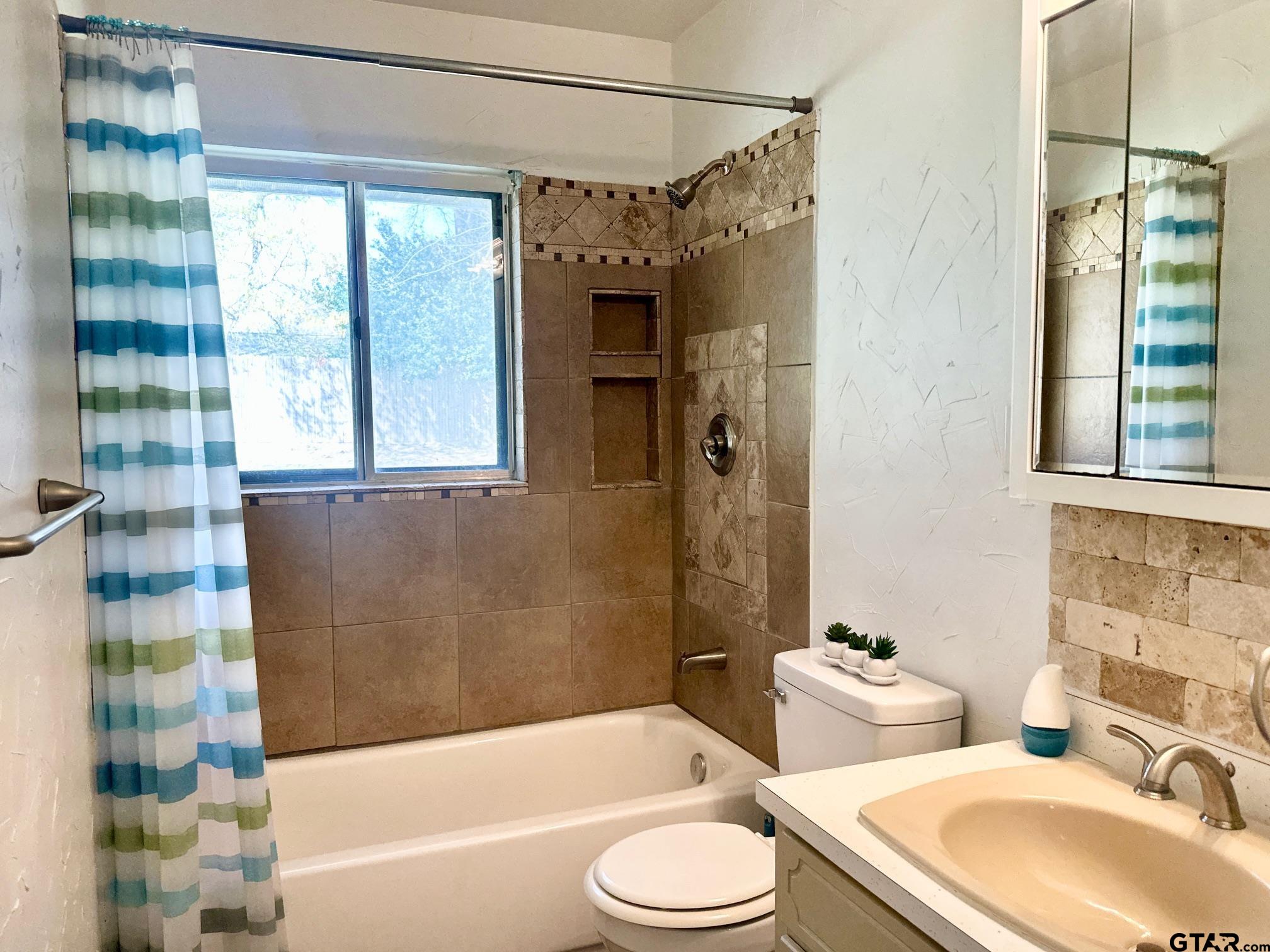2412 East Devine Street Tyler, TX 75701 - Photo 16 of 27 a bathroom with a sink toilet bathtub and shower